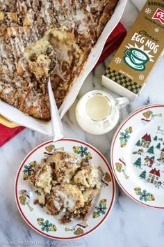 a table topped with plates filled with food next to a box of egg nog