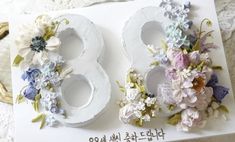 two white plates with flowers on them sitting on a table next to a pair of scissors