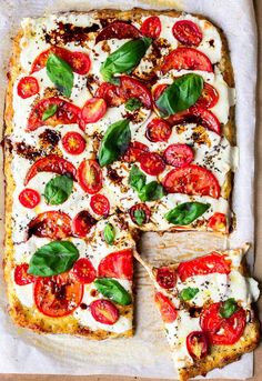 a pizza with tomatoes, cheese and basil on it