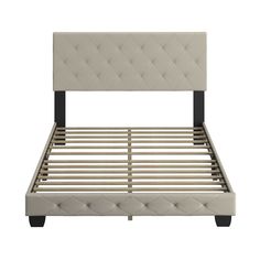 an upholstered bed frame with wooden slats and buttons on the headboard