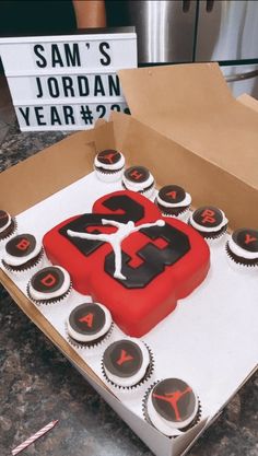 a birthday cake in the shape of an air jordan shoe on top of cupcakes