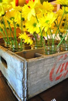 some yellow flowers are in mason jars on a table