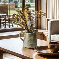 a vase with flowers sitting on top of a table next to a cup and saucer