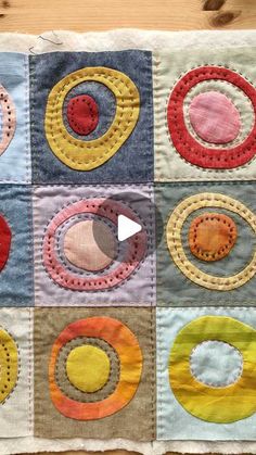 a patchwork quilt with circles on it and a video play button in the middle