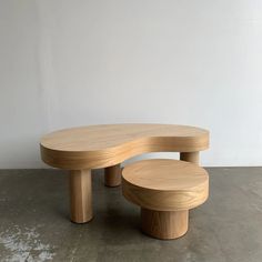 two wooden benches sitting on top of a cement floor next to a white walled wall