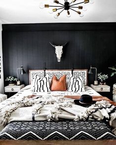 a black and white bedroom with an animal skull on the wall above the headboard