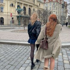 two women are walking down the street together