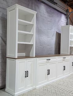 the cabinets are all white and have wood tops on them, but no one is in it