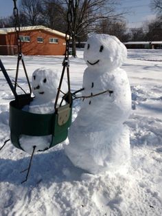 two snowmen are sitting on swings in the snow and one is holding a swing