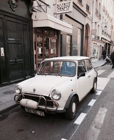 an old car is parked on the side of the street