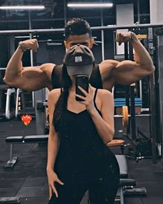 a woman standing next to a man in a gym