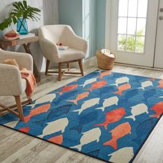 a blue rug with orange and white fish on it in front of a door way