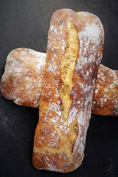 two loaves of bread sitting on top of a black counter next to each other