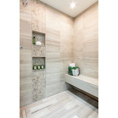 a white tiled bathroom with shelves on the wall