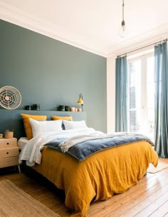 a bedroom with blue walls and yellow bedding