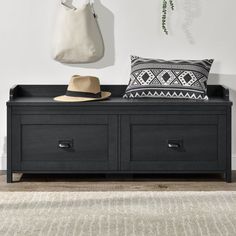 a black bench with two drawers and a hat on it