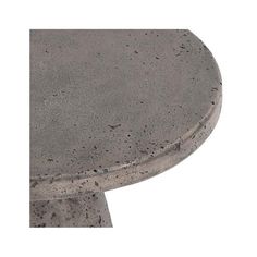 a round concrete table with black speckles on the top and bottom, against a white background