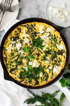 an omelet with spinach and feta cheese in a cast iron skillet