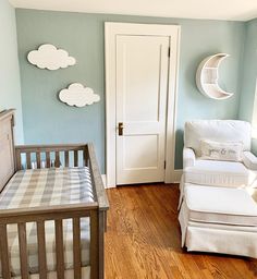 a baby's room with blue walls and white furniture