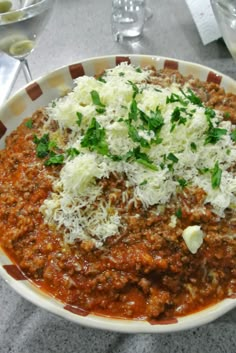 a bowl filled with meat and cheese on top of a table