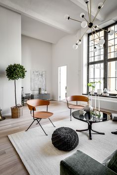 a living room filled with furniture and large windows