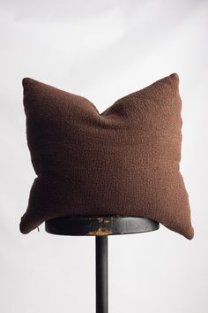 a brown pillow sitting on top of a metal table