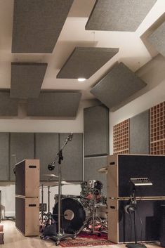 a recording studio with sound equipment in the foreground and acoustic speakers on the far wall