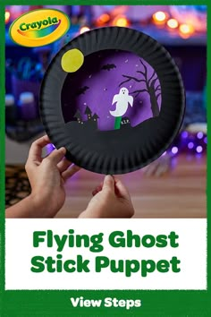 a hand holding a paper plate with a ghost on it and the words flying ghost stick puppet