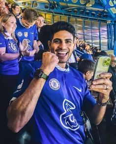 a man taking a selfie with his cell phone in front of him at a soccer game