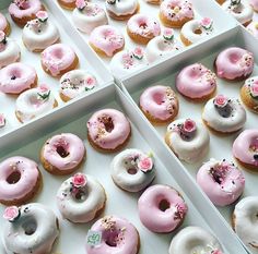 three boxes filled with pink and white donuts