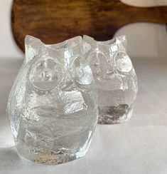 two clear glass owls sitting next to each other