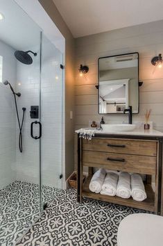 a bathroom with a sink, mirror and shower stall in the middle of the room