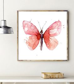 a watercolor painting of a pink butterfly on a white wall