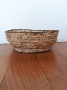 a woven basket sitting on top of a wooden floor