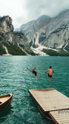 two people jumping into the water from boats