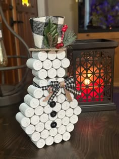 a snowman made out of wine corks on a table next to a lantern