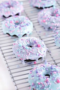 donuts with sprinkles are cooling on a rack