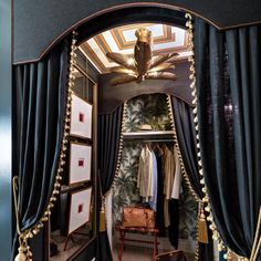 the closet is decorated with black curtains and gold tassels, along with pictures on the wall