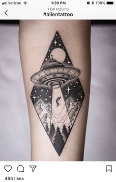 a black and white tattoo with an alien spaceship in the sky above it, surrounded by mountains