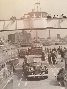 an old black and white photo of cars driving on the road