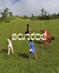 some people are standing in the grass and one is holding a sign that says sottos