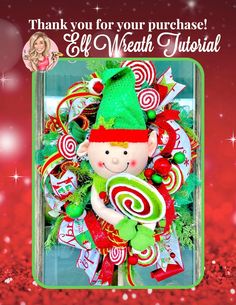 a christmas wreath with candy canes and an elf on it's head, in front of a red background