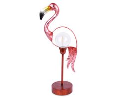 a pink flamingo standing on top of a wooden stand with a glass ball in it's beak