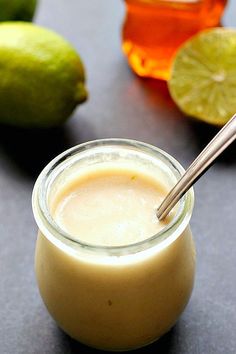 a glass jar filled with liquid next to limes