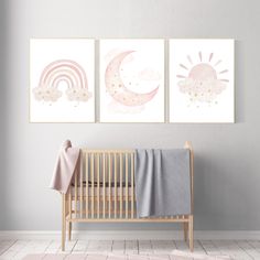 a baby's room with two paintings on the wall and a crib next to it