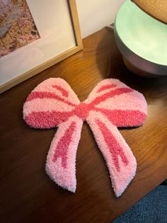 a pink and white candy cane shaped rug sitting on top of a wooden table next to a lamp