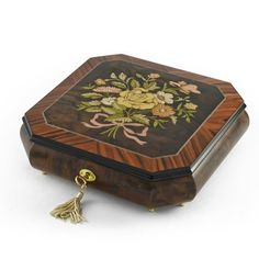 an ornate wooden box with floral designs and tassels on the lid is shown