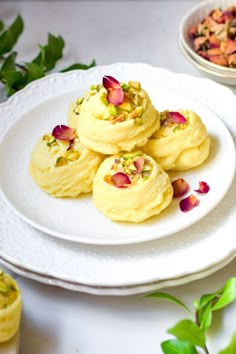 some food is on a white plate and next to other plates with flowers in them