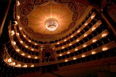 the interior of an auditorium with chandeliers and lights on it's ceiling