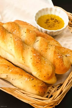 two loaves of bread sitting on top of a table next to a bowl of mustard